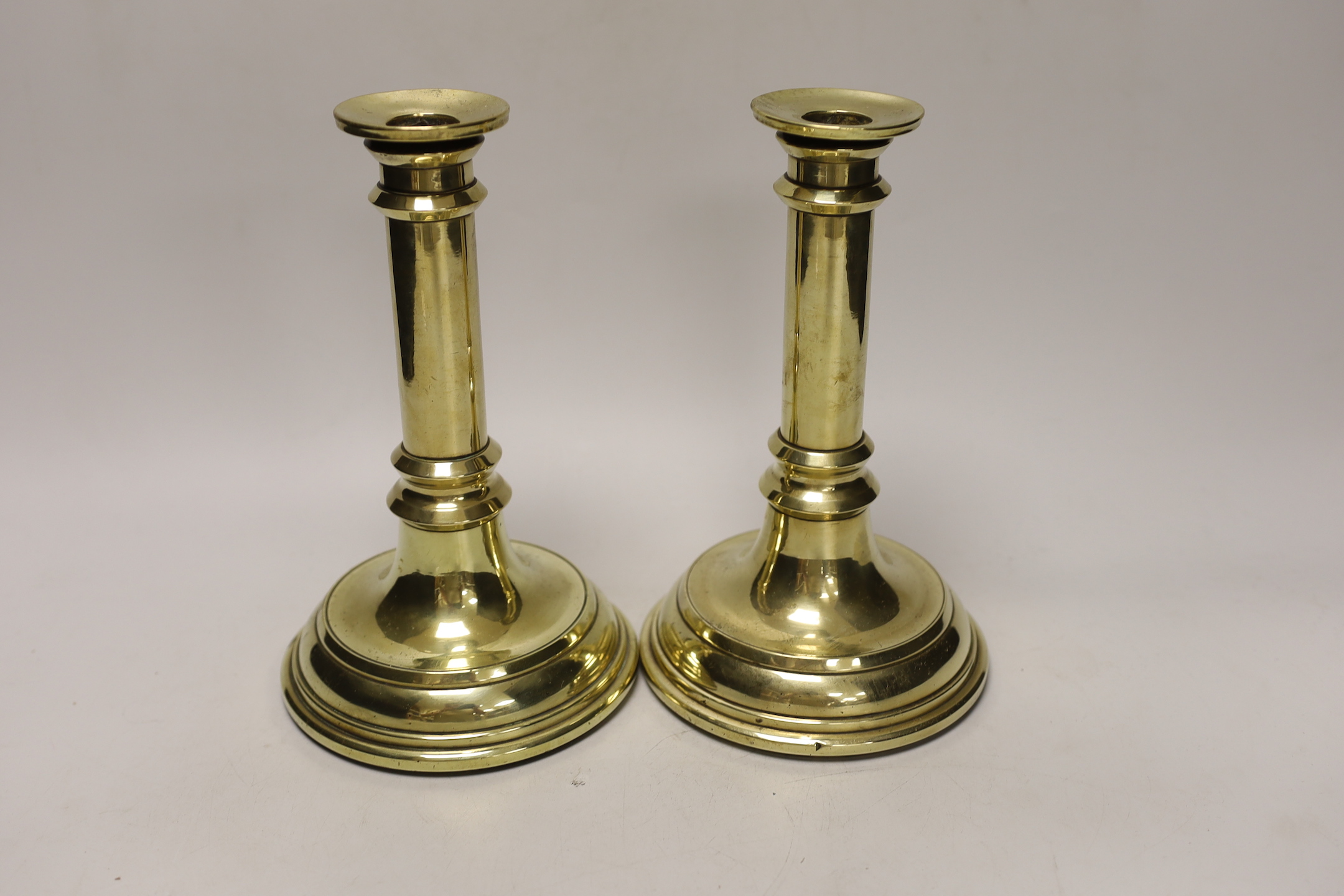 A pair of Victorian brass candlesticks possibly from House of Commons or military consecutively numbered, 21.5cm tall